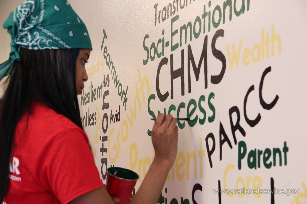 AmeriCorps member paints a mural