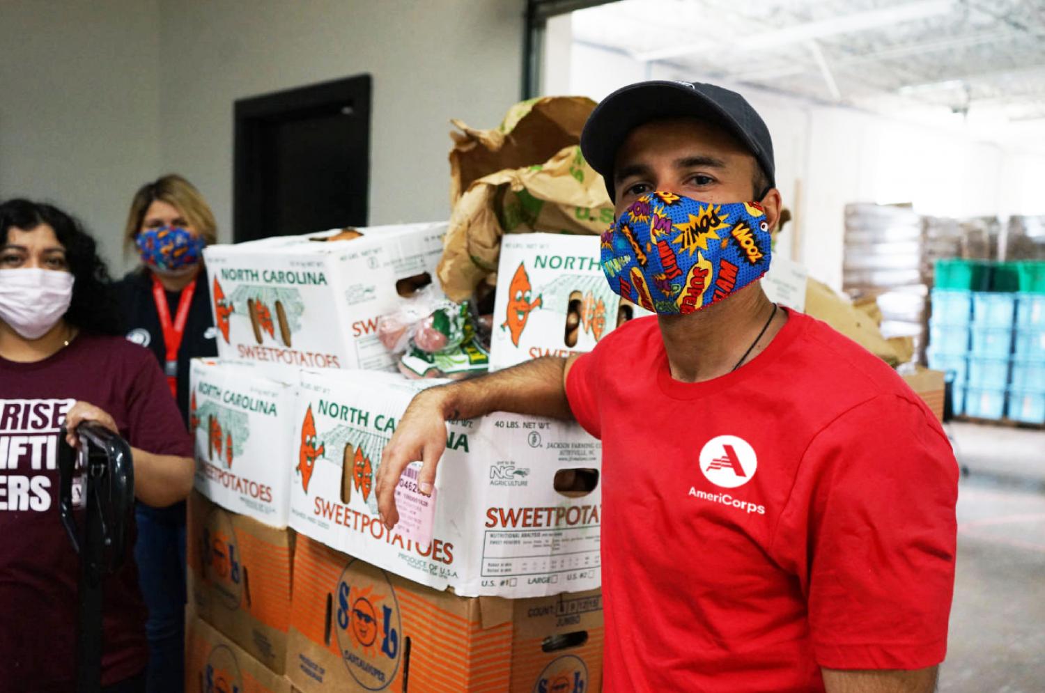 AmeriCorps member unloading food.