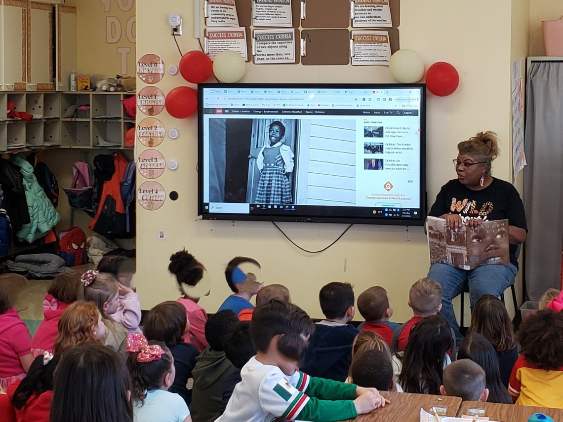 Grandma Belinda reads to a class of kindergarten students