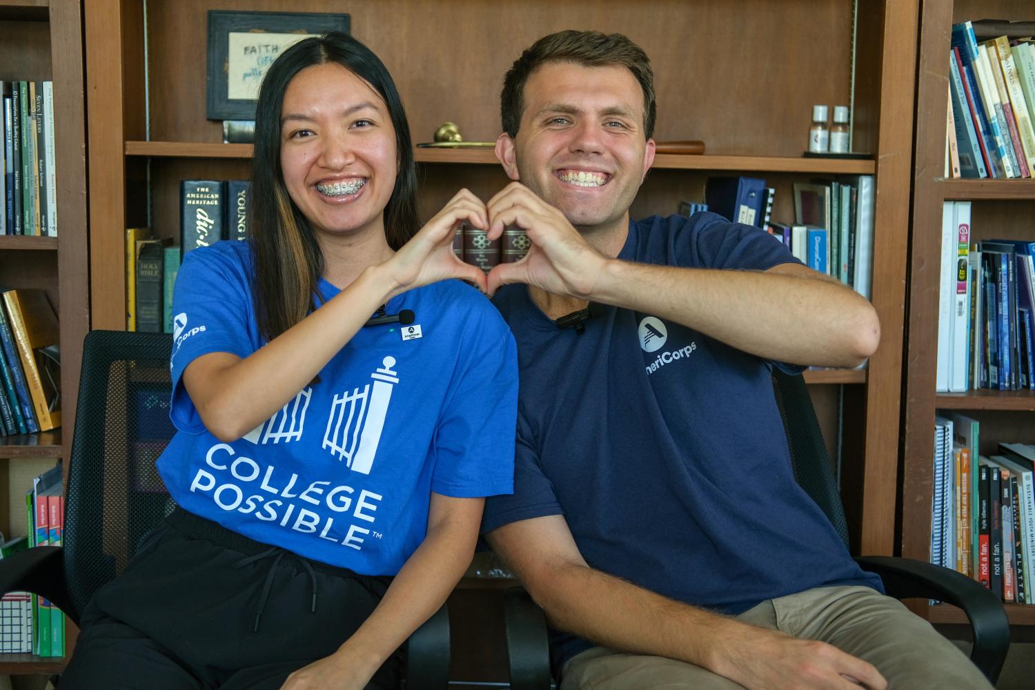 Two AmeriCorps alums posing together with their hands in the shape of a heart