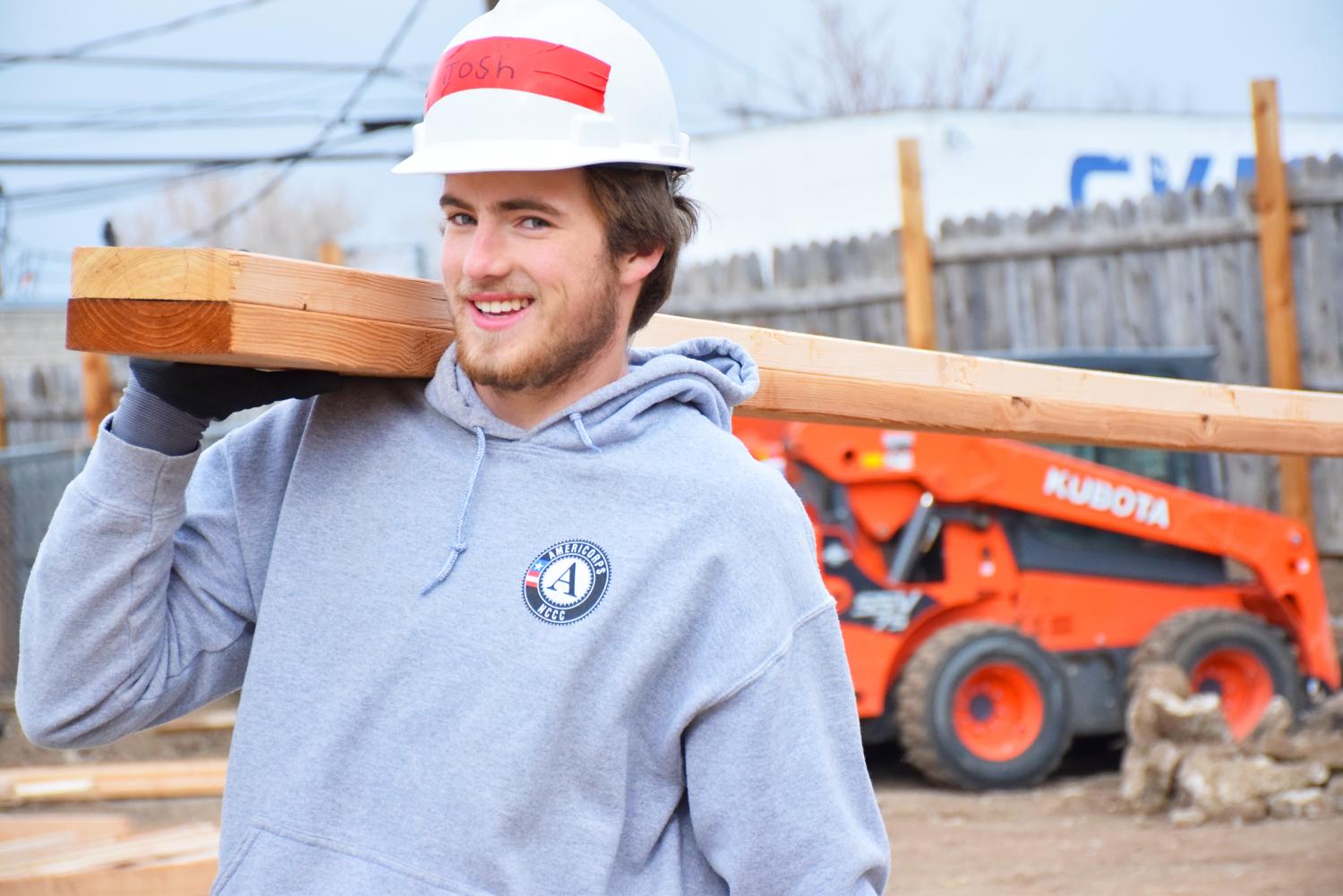 AmeriCorps Member holding lumber