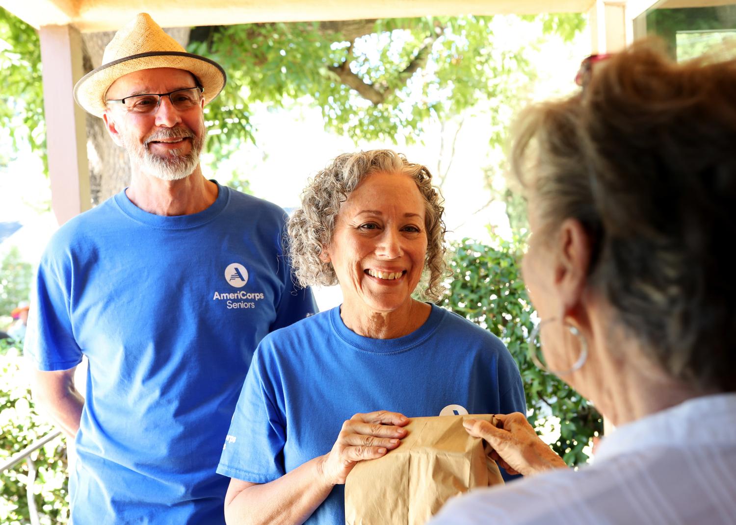 AmeriCorps Seniors volunteers delivering meals to another older American.