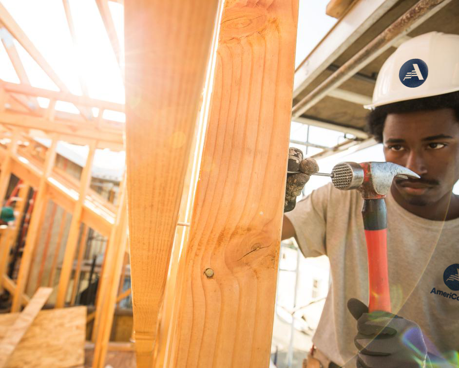 Man hammering a nail into wood on a building site