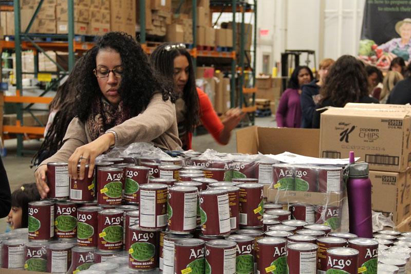 Volunteers packing cans of vegetables