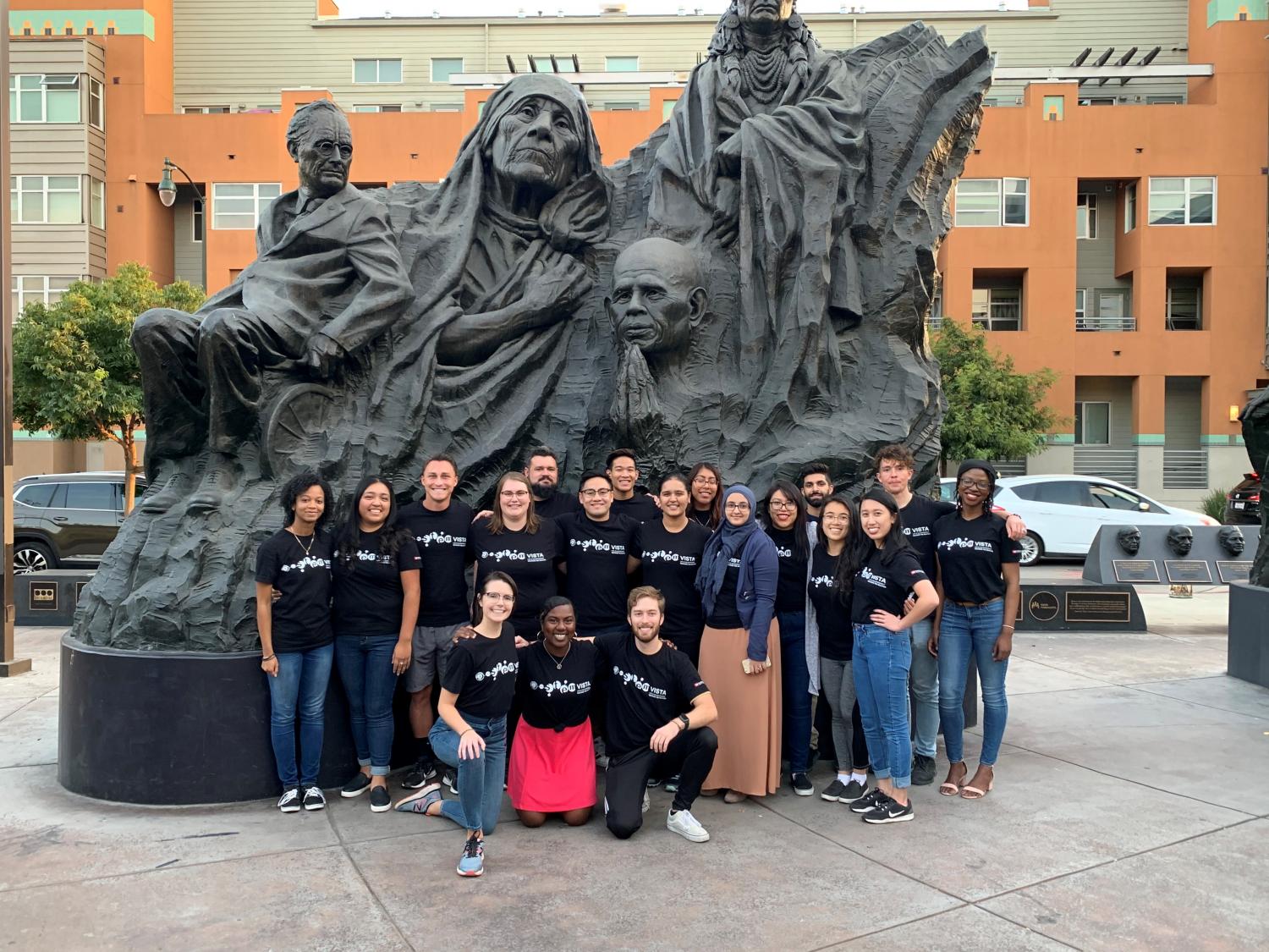 Emily Ward and her colleagues pose in front of a sculpture.